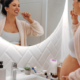 Schwangere Frau putzt sich vor dem Badezimmerspiegel die Zähne